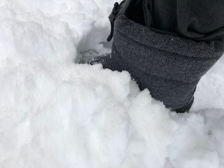 ヌプシブーティのウール素材で雪の上を歩いている